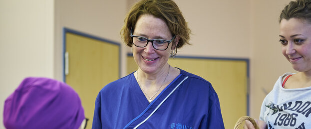 Pflegekräfte übergeben ein Geschenk an eine Patientin