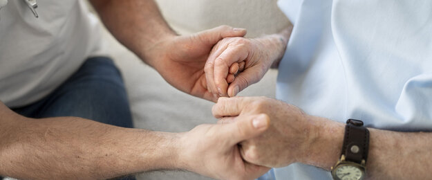 Parkinsonpatient hält Hand einer Angehörigen