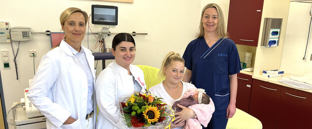Die glückliche Mutter mit Baby und dem Team des Kreißsaals